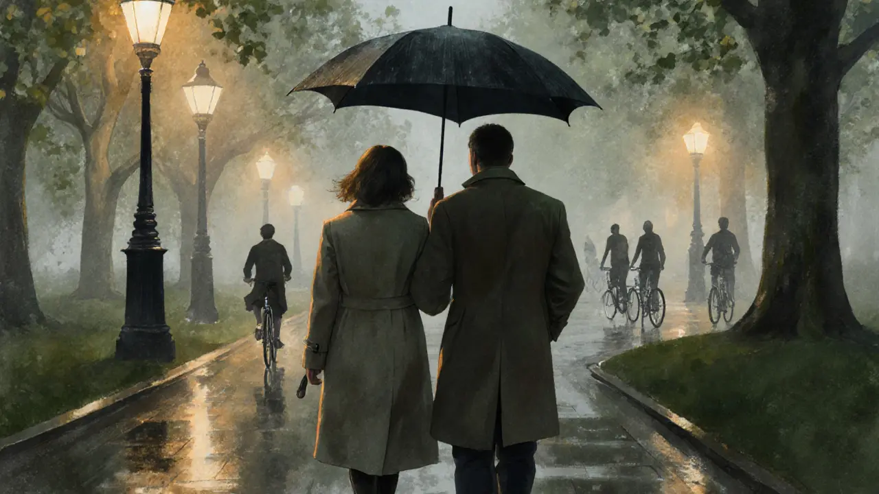 A couple walks quietly together under an umbrella in Hyde Park at night, rain falling softly around them.